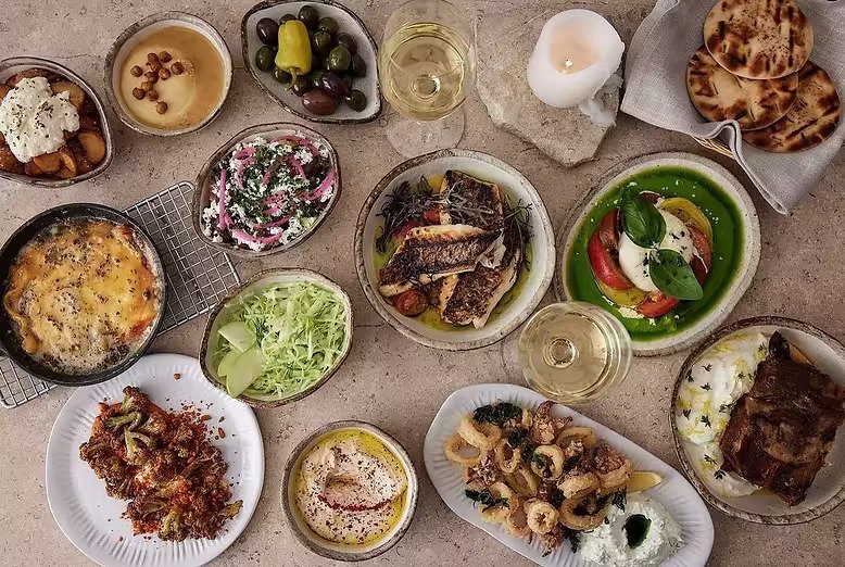 A spread of traditional Ikarian Blue Zone dishes including salads, seafood and mezze