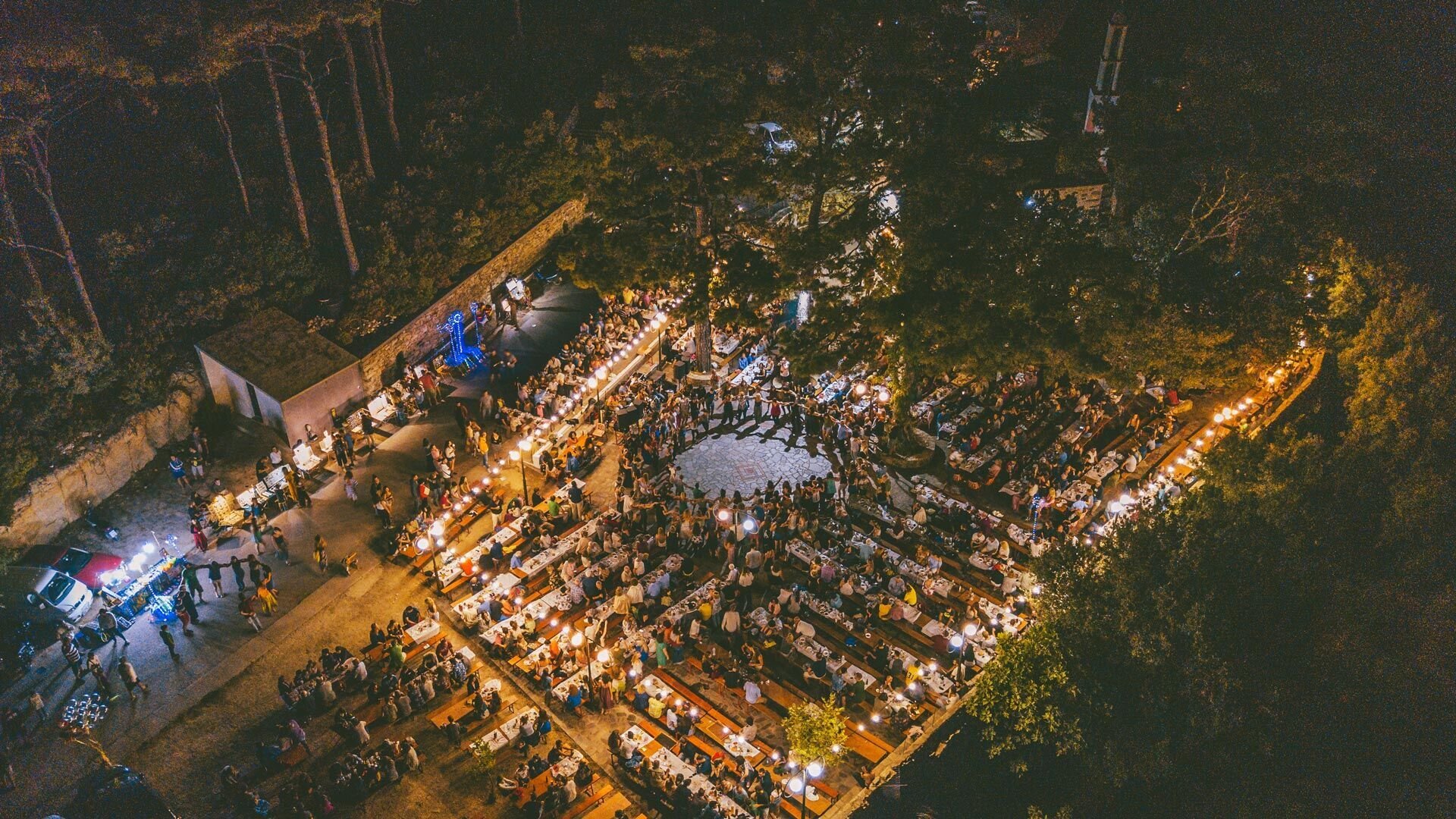 A traditional panigiri festival under string lights in Ikaria